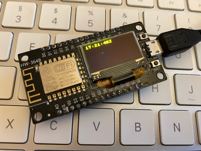 A combined ESP8266 and OLED board sitting on an Apple keyboard