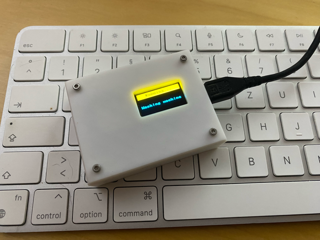 A combined ESP8266 and OLED board sitting on an Apple keyboard